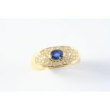 A SAPPHIRE AND DIAMOND RING the oval-shaped sapphire is set within a surround of circular-cut