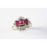 A RUBY AND DIAMOND CLUSTER RING the three oval-shaped rubies are set within a surround of single-cut
