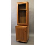 ERCOL - NARROW GLAZED CABINET/CUPBOARD a narrow light elm cabinet with glazed top section and 2