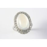 A MOONSTONE AND DIAMOND CLUSTER RING the oval-shaped moonstone is set within a surround of