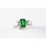 A TSAVORITE GARNET AND DIAMOND THREE STONE RING the cushion-shaped garnet weighs approximately 3.