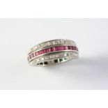 A RUBY, EMERALD AND DIAMOND SWIVEL ETERNITY RING set with circular-cut diamonds and calibre-cut