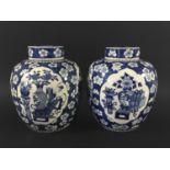 PAIR OF CHINESE BLUE AND WHITE GINGER JARS AND COVERS painted with ogee cartouches of vases on a