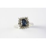 A SAPPHIRE AND DIAMOND CLUSTER RING the oval-shaped sapphire is set within a surround of circular-