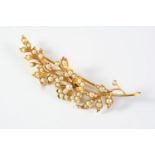 AN EDWARDIAN PEARL AND GOLD FOLIATE SPRAY BROOCH set overall with graduated half pearls, in 18ct