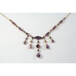 AN AMETHYST AND GOLD DROP NECKLACE mounted with seven graduated marquise-shaped amethysts on a