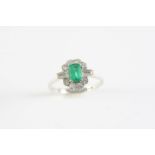 AN EMERALD AND DIAMOND CLUSTER RING the rectangular-shaped emerald is set within a surround of two
