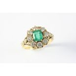 AN EMERALD AND DIAMOND CLUSTER RING the cut cornered rectangular-shaped emerald is set within a