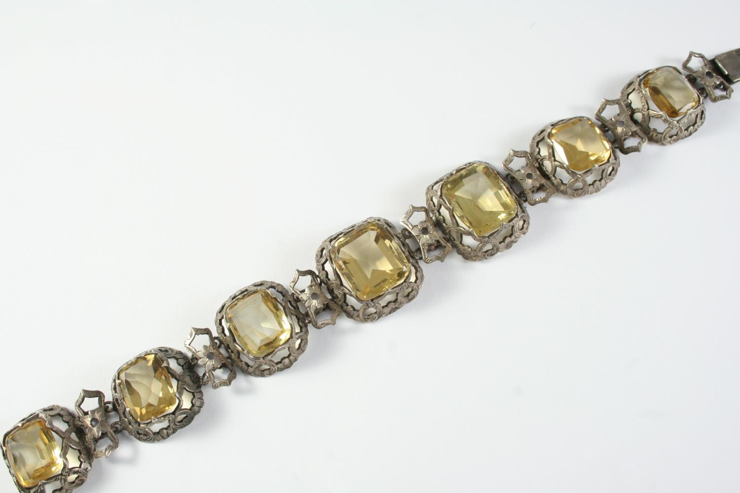 A VICTORIAN CITRINE AND SILVER BRACELET formed with graduated citrines in silver openwork mounts,