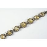 A VICTORIAN CITRINE AND SILVER BRACELET formed with graduated citrines in silver openwork mounts,