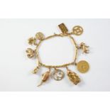A GOLD CHARM BRACELET suspending assorted gold charms, total weight 26 grams