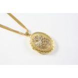 AN 18CT GOLD LOCKET PENDANT with embossed decoration to the front case depicting a bird amongst