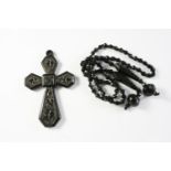 A JET CRUCIFORM PENDANT AND NECKLACE the pendant embossed with foliate decoration, 8.5 x 5.5cm,