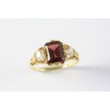 A GARNET AND DIAMOND RING the rectangular-shaped garnet is set with a cushion-shaped diamond to each