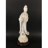 CHINESE BLANC DE CHINE FIGURE OF GUANYIN standing pouring from a vase, with ruyi pendants to the