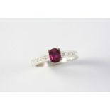 A RUBY AND DIAMOND RING the oval-shaped ruby is set with five baguette-cut diamonds to each