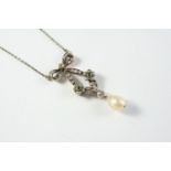 A BELLE EPOQUE NATURAL PEARL AND DIAMOND PENDANT the diamond set bow and foliate mount suspends a