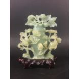 CHINESE GREEN JADE VASE 20th century, carved with flowering foliage, on a hardwood stand, height