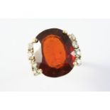 A SPESSARTITE GARNET AND DIAMOND RING the large oval-shaped garnet is set with four diamonds to each