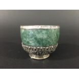 TIBETAN HARDSTONE AND WHITE METAL MOUNTED CUP possibly jade, the mounts embossed with the eight