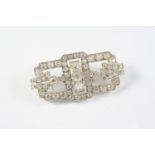 AN ART DECO DIAMOND PLAQUE BROOCH the openwork design is centred with three cushion-shaped