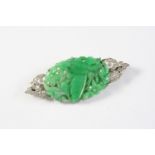 AN ART DECO JADE AND DIAMOND BROOCH set with an oval-shaped foliate carved and pierced jadeite