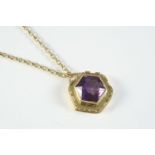 AN AMETHYST AND GOLD PENDANT the octagonal shaped pendant is set in a 9ct gold mount, on a 9ct