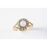 AN OPAL AND DIAMOND CLUSTER RING the circular solid white opal is set within a surround of rose-