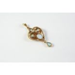 AN OPAL AND GOLD PENDANT the oval-shaped opal is set within a gold openwork surround set with