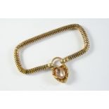 A VICTORIAN SNAKE LINK BRACELET with scrolling embossed padlock clasp mounted with a foiled backed