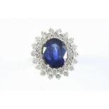 A SAPPHIRE AND DIAMOND CLUSTER RING the oval-shaped sapphire weighs approximately 4.80 carats and is