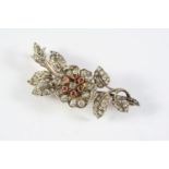 A VICTORIAN DIAMOND AND RUBY FOLIATE SPRAY BROOCH the central flowerhead set en tremblant, the