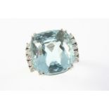 AN AQUAMARINE AND DIAMOND CLUSTER RING the cushion-shaped aquamarine weighs approximately 27.0