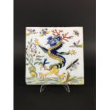 FRENCH FAIENCE TILE potentially 18th century, painted with a chinoiserie dragon, birds and