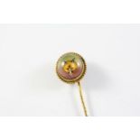 A CRYSTAL REVERSE CARVED INTAGLIO STICK PIN depicting a fox mask, in gilt metal surround