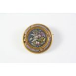 AN ANTIQUE MICROMOSAIC BROOCH of circular form, depicting birds amongst foliate, mounted in gold,