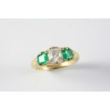 AN EMERALD AND DIAMOND THREE STONE RING the cushion-shaped diamond weighs approximately 1.60 carats,