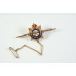 A 9CT GOLD AND ENAMEL REGIMENTAL BROOCH FOR THE ROYAL ARMY SERVICE CORPS with red and blue enamel