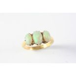 AN OPAL THREE STONE RING the three graduated oval solid white opals are set in 18ct gold, hallmarked