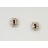 A PAIR OF RUBY AND DIAMOND CLUSTER STUD EARRINGS each earring is set with an oval-shaped ruby within