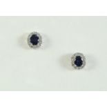 A PAIR OF SAPPHIRE AND DIAMOND STUD EARRINGS each earring set with an oval-shaped sapphire within