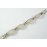 A ROCK CRYSTAL AND DIAMOND BRACELET formed with carved sections of rock crystal each divided by a