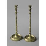 PAIR OF BRASS CANDLESTICKS possibly early 18th century, the banded sconce on a tapering, knopped