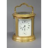 FRENCH GILT METAL OVAL CARRIAGE CLOCK late 19th century, the enamelled dial with Roman numerals