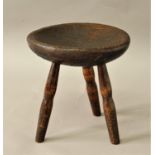 RUSTIC MILKING STOOL the near circular seat, possibly oak, on three turned legs, height 35cm,