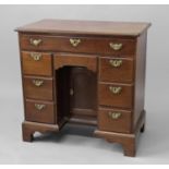 GEORGE III MAHOGANY KNEEHOLE DESK a frieze drawer above a kneehole drawer and cupboard flanked by