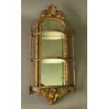 GILT GESSO MIRRORED WALL SHELF early/mid 19th century, the three serpentine shelves with a