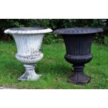 SET OF FOUR CAST IRON GARDEN URNS of flared, reeded form, on a socle base and square foot, two