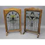 PAIR OF ARTS AND CRAFTS STYLE FIRESCREENS the floral, leaded glass, panels mounted in oak frames,