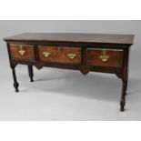 GEORGE III OAK DRESSER BASE the two plank top above three drawers, shaped apron and tapering, turned